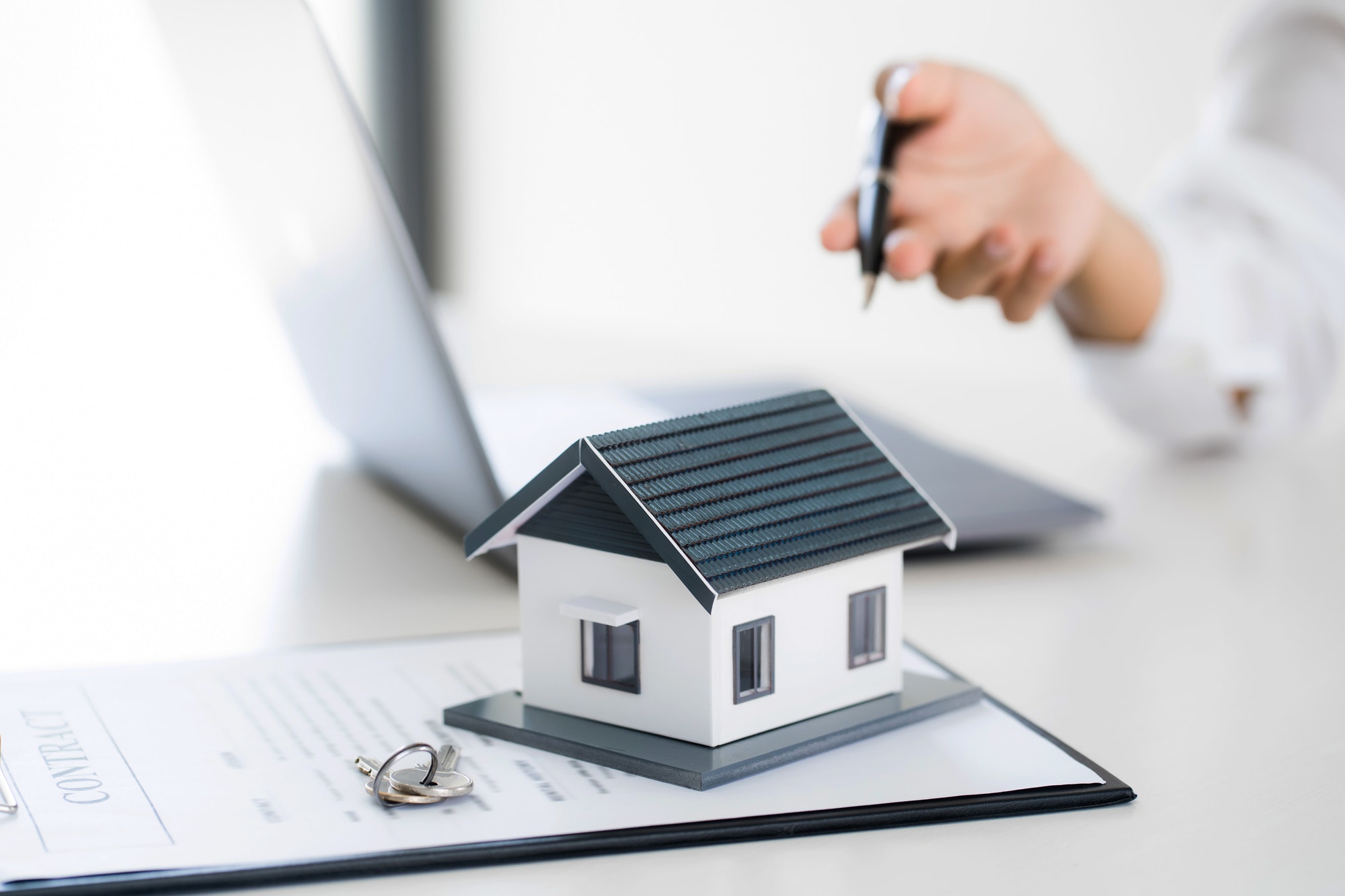 Real estate agent broker and customer with loan or insurance contract documents.